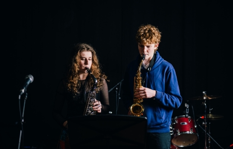 Two music students performing the saxophone on stage