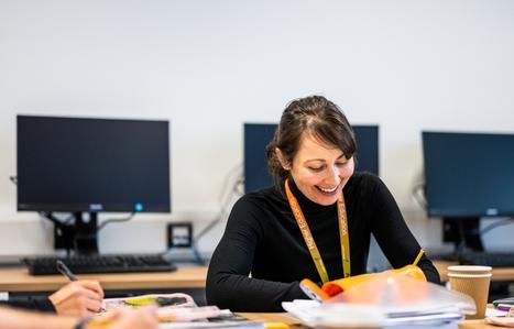 female student smiling and writing