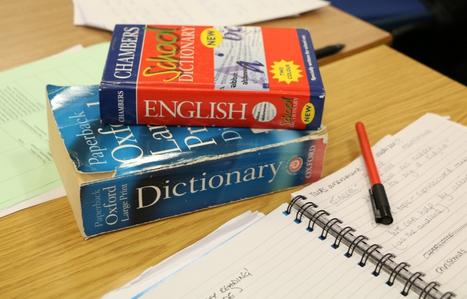 dictionaries on a table with pen and paper