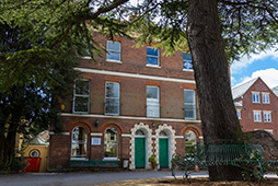 Exterior of Globe Centre red brick building with large pine tree in the front