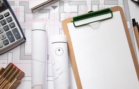 Construction concept. Residential building blueprint drawings and office supplies