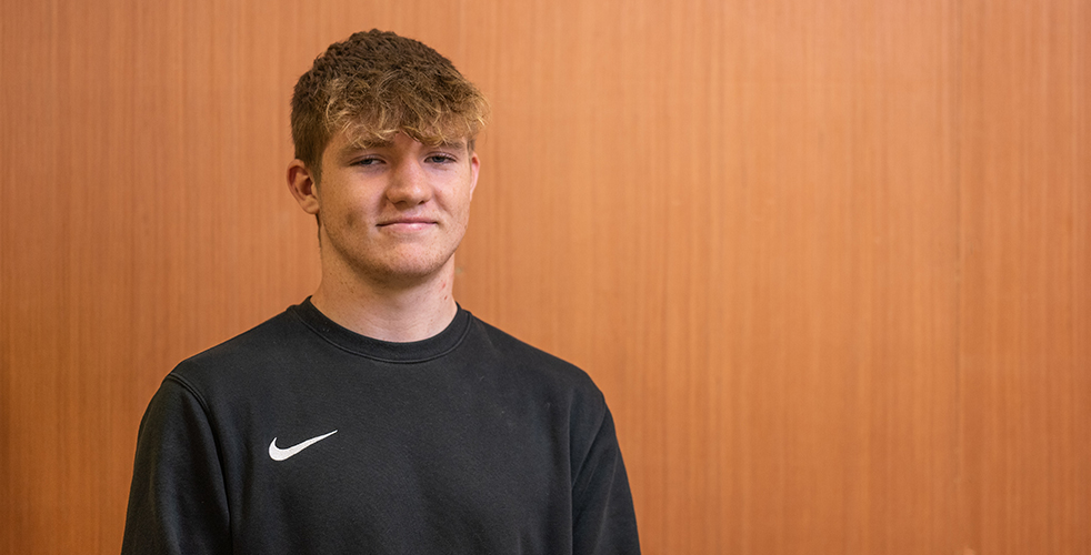 Male Student portrait smiling at the camera wearing a black sweatshirt