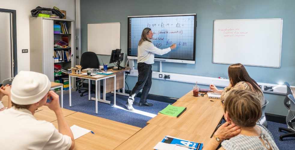 Adults learning maths in a classroom