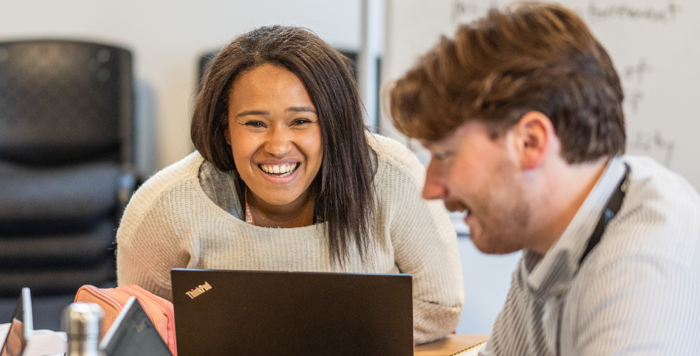 Two students working and smiling