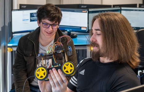 Two students looking at a robot