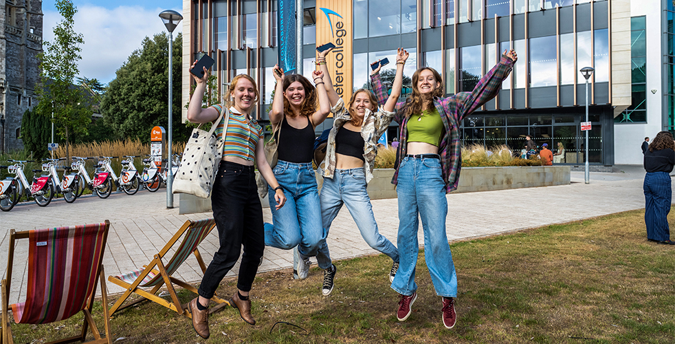 Female Students Jumping with joy on Results Day 2022 on the Hele Road Campus