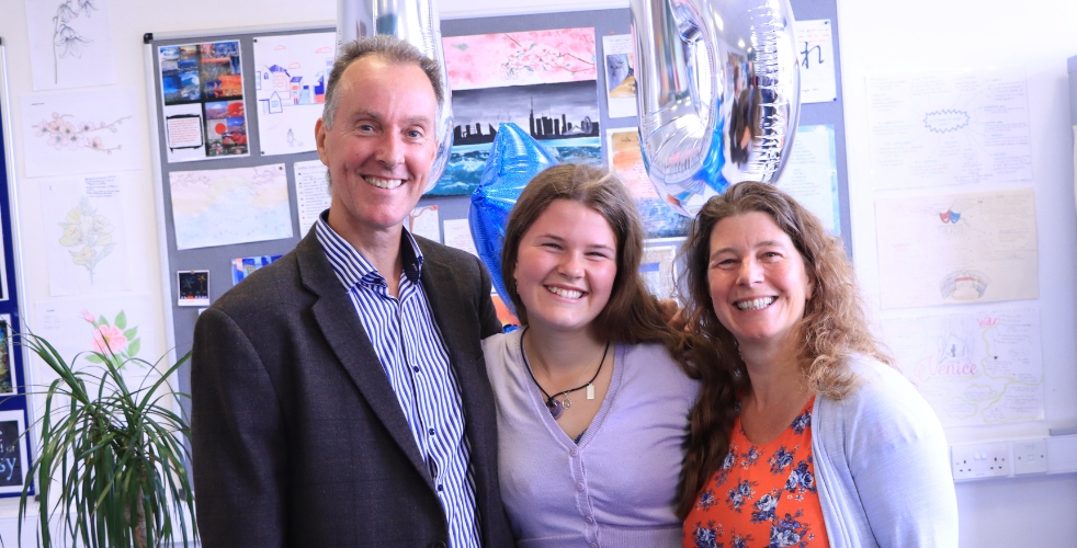 Student and parents smiling at the camera