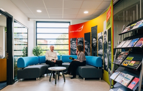 An image of two people sitting, chatting in the Adult Learning Hub at College