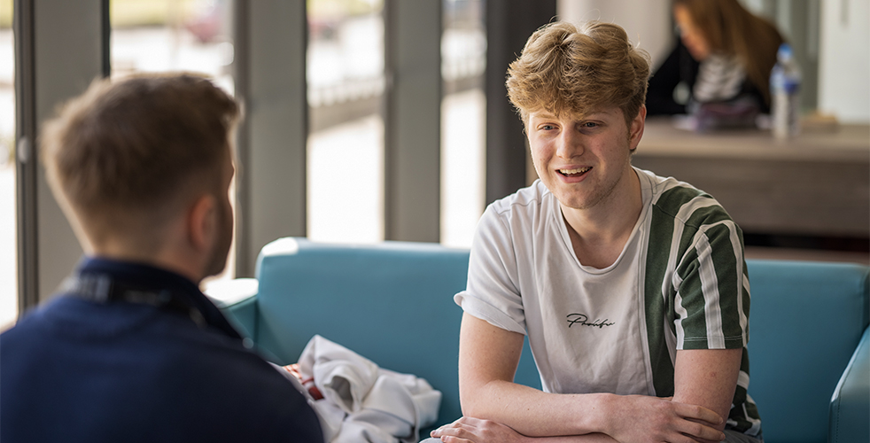 A member of the College Advice Team talking to a learner in a college cafe