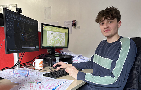 Luke, Civil Engineering Apprentice sitting at a desk working on a project at his employer