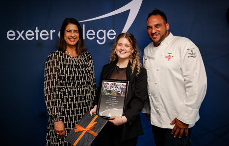 Chair of governors Bindu Arjoon and Michael Caines present a student with her graduating certificate