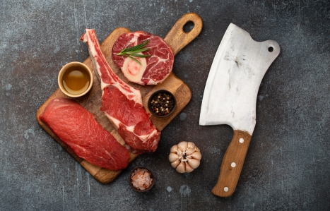 Assorted meat cuts and a large butchery knives