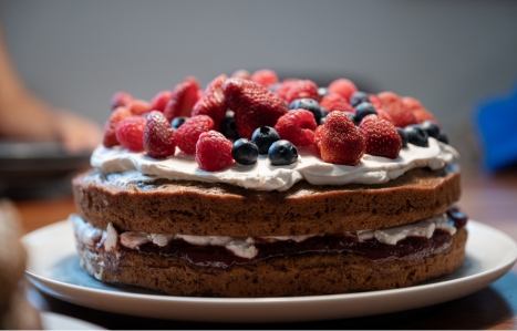 a sponge cake with cream and lots of berries on top