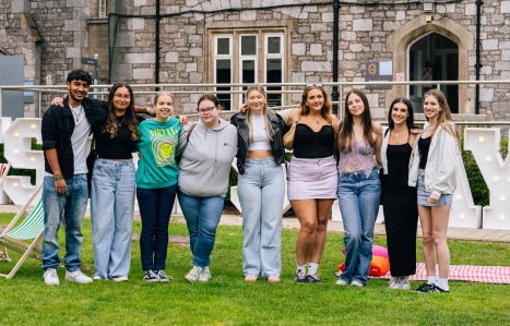 A group of students stand together and celebrate their exam results