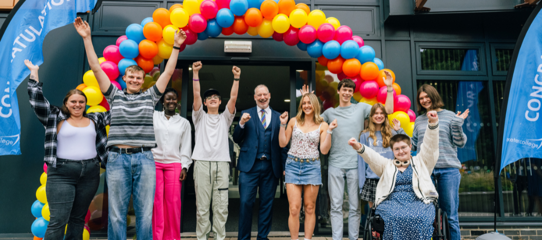 Exeter College celebrate opening their results under a balloon arch