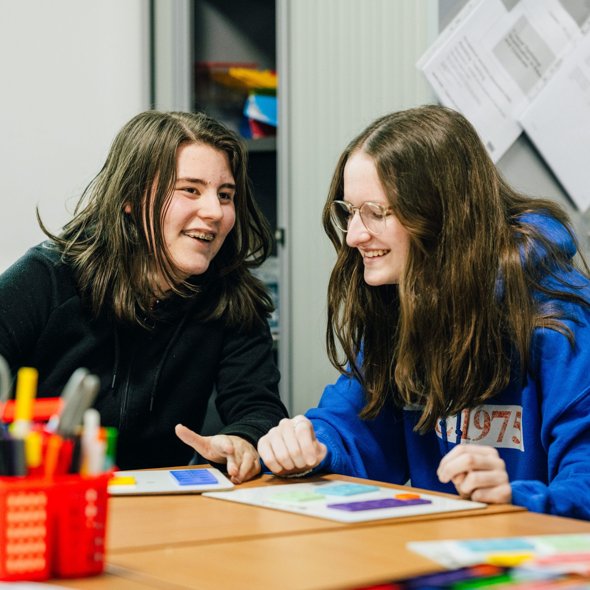 Two students laugh in a classroom