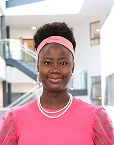 Women smiling at the camera in a pink top