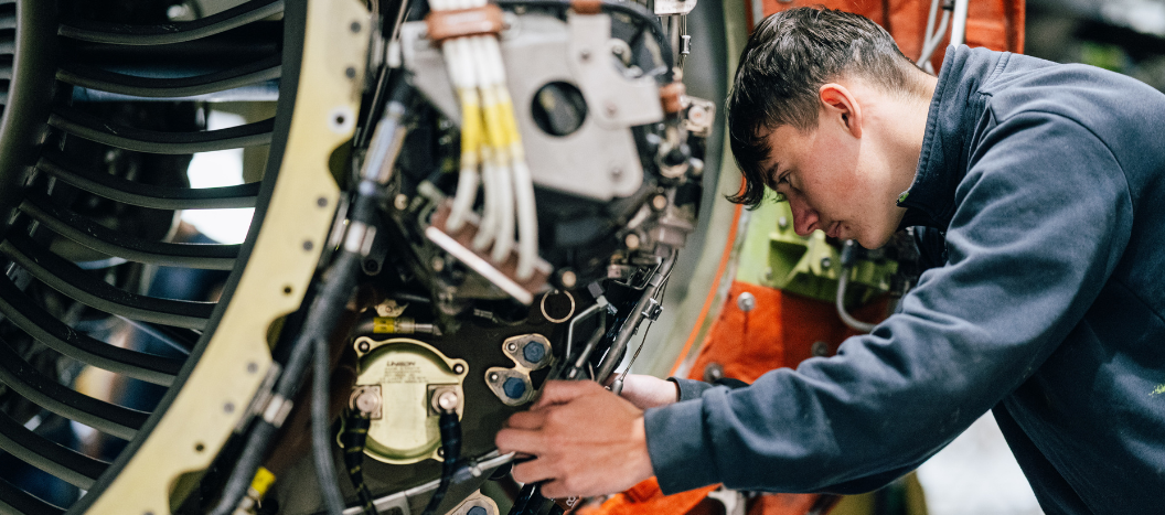 An engineering student tinkers with a plane engine