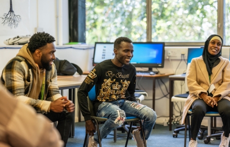 Three YES Plus students sat in a class room smiling 