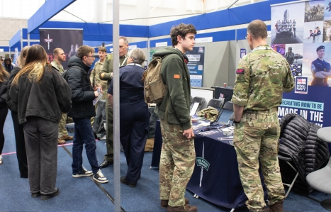 students at an Army stand at the Expo speaking to the employer