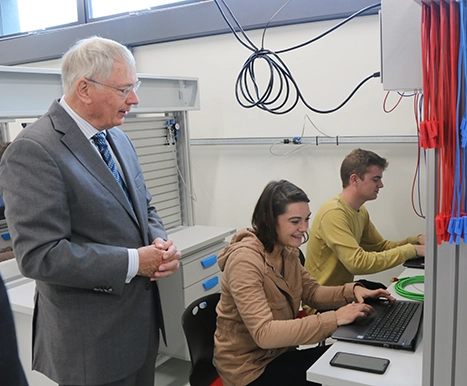 Duke of Gloucester visiting two students watching over their digital work
