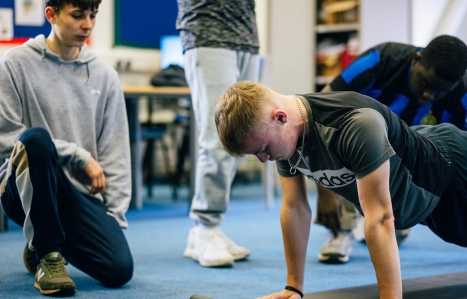 A student doing a press up in the classroom