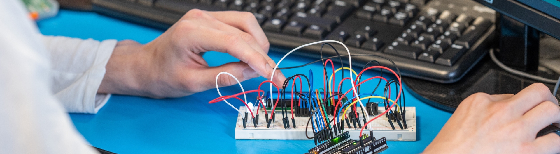 hands working on an electronic board
