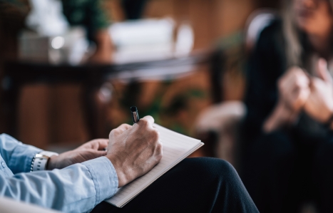 A counsellor or therapist's clipboard and someone in the background