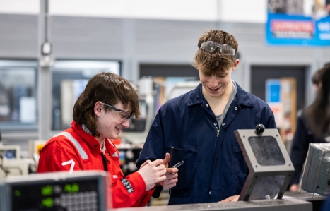 Two engineering students smiling at machinery
