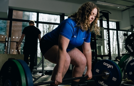 Student in the gym lifting weights