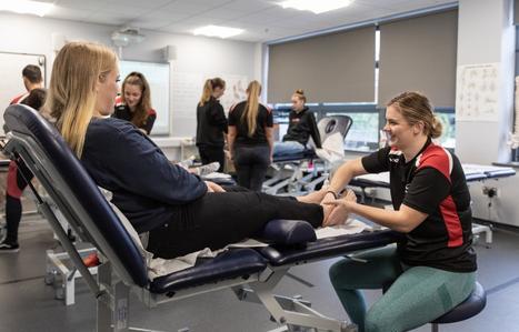 Sports therapy student massaging a person ankle