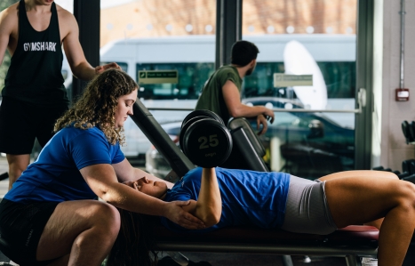 Student lifting weights in the college gym