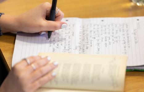 student hand with pen on paper