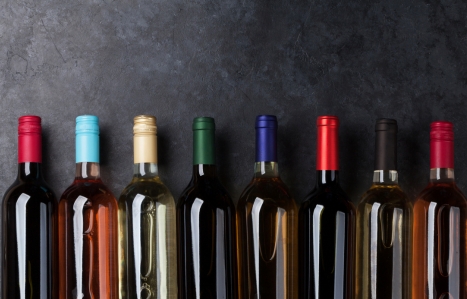 Red, rose and white wine bottles in a line