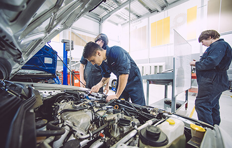 Apprenticeship student working on a car in a garage