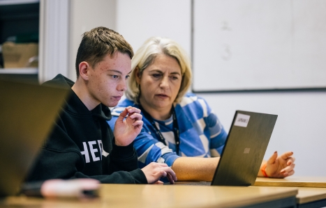 A student and tutor looking at a laptop screen