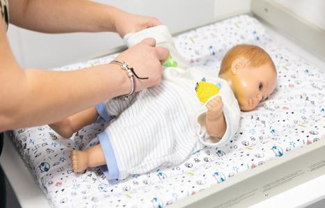 hands changing a baby model