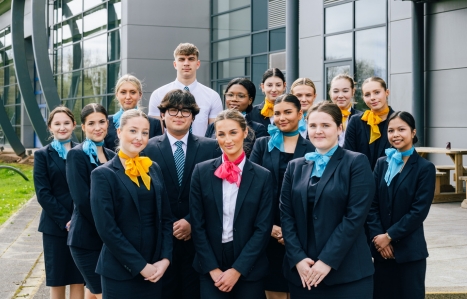 a large group of travel and tourism students outside the Future Skills Centre smiling at the camera