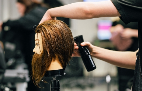 A barbering dummy head being sprayed with water