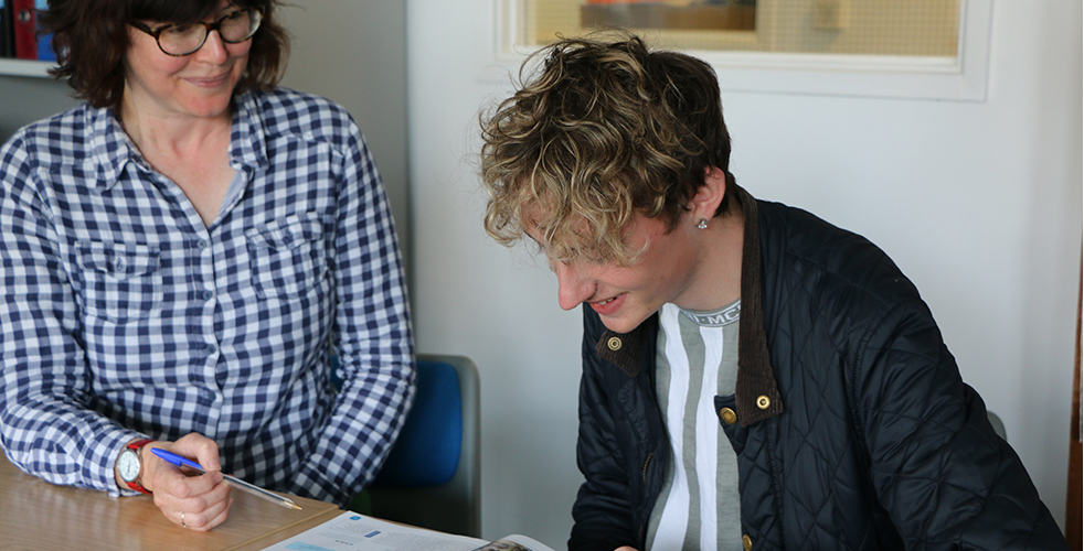 Student and Staff working together on a work sheet