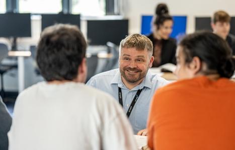 Teacher speaking to students at their desk