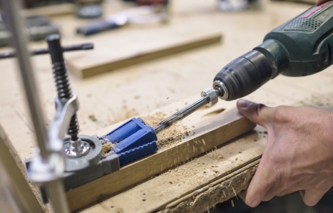Carpenter installs furniture hinge