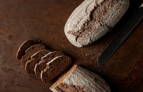 top view of bread, slices and knife on rusty metal table