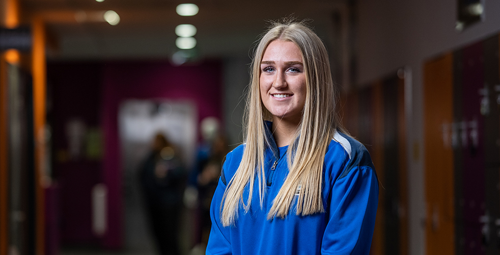 female Student portrait smiling at the camera in the Exeter College sports academy kit