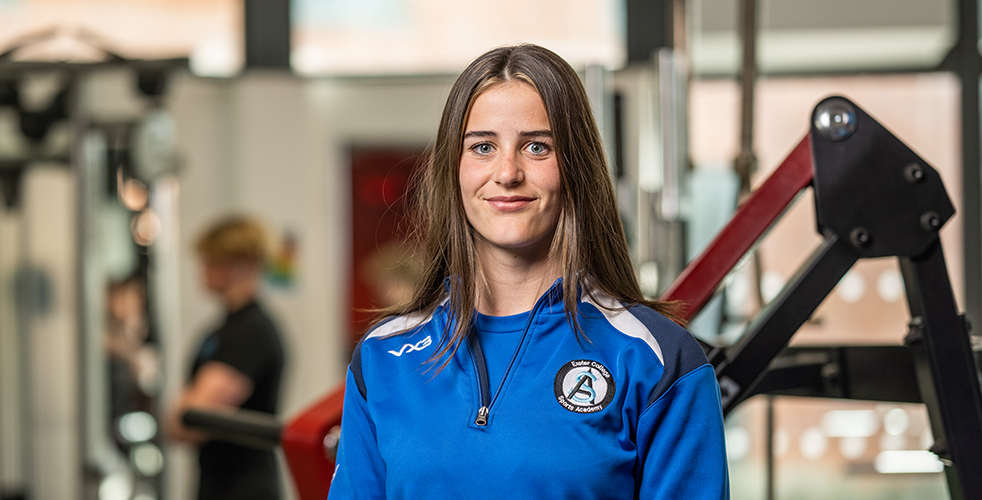female Student portrait smiling at the camera in the Exeter College sports academy kit