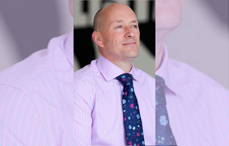 Portrait of man in a pink stripped shirt and a blue colourful tie