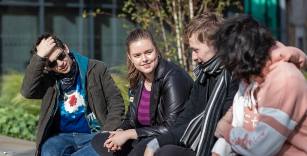 Four students sat outside talking