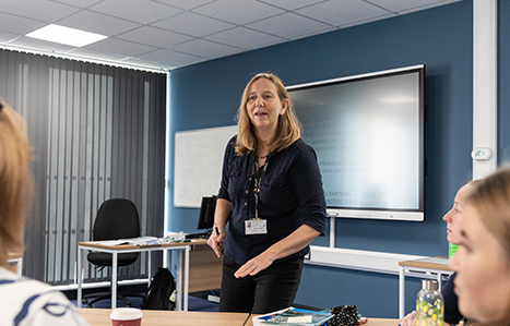 Teacher talking to class from the front of the classroom