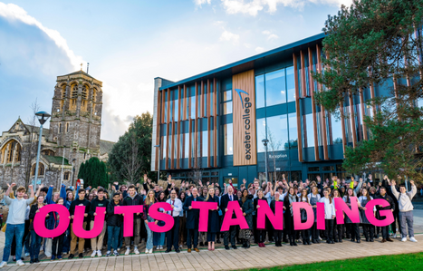 Students and staff stood outside the IoT holding a letter spelling out outstanding