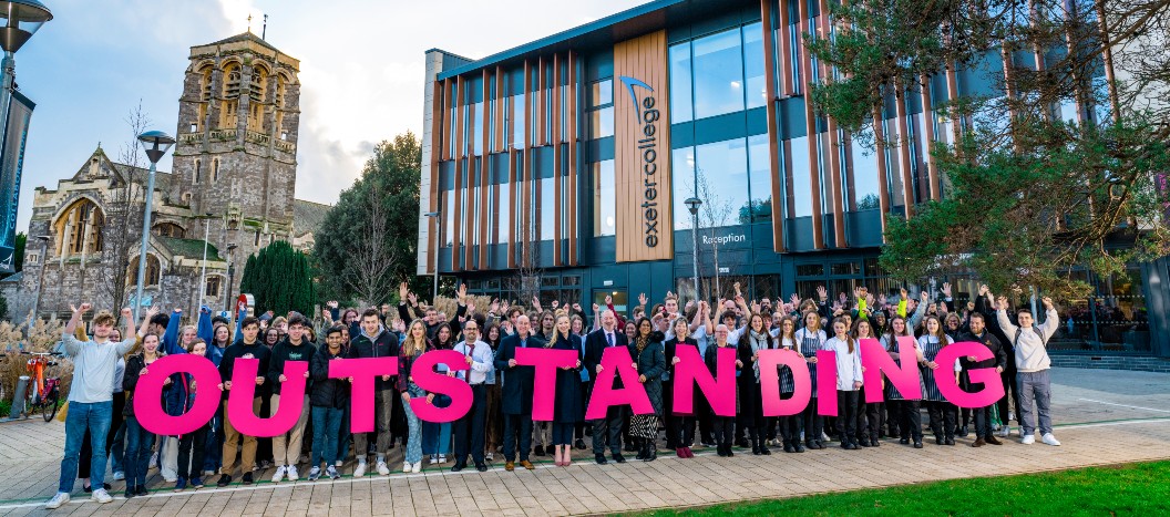 Students and staff stood outside the IoT holding a letter spelling out outstanding